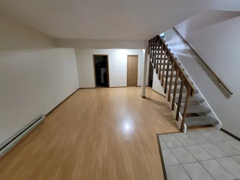 Deluxe living room with wood-look flooring and an open staircase