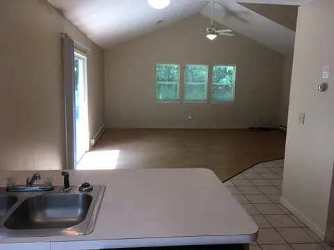Premier interior with a vaulted living area and three windows, viewed from the kitchen