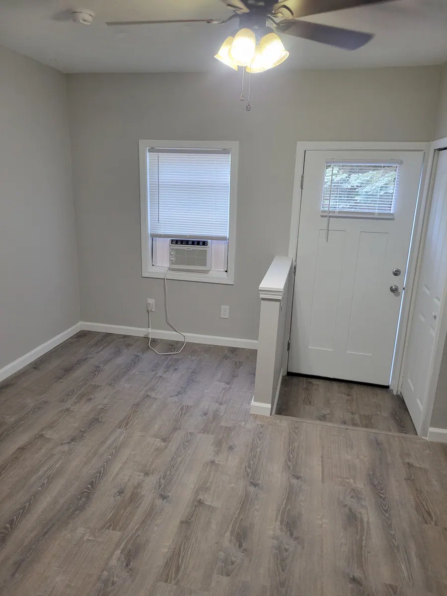 Studio living space with a ceiling fan, window and exterior door